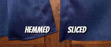 Two pieces of dark blue, shiny curtain fabric separated by a wooden window mullion. One is hemmed on the bottom. The other is cut, with loose strings dangling from the bottom.