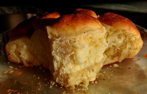 Fluffy dinner rolls with buttery, golden brown tops and flecks of chives inside.