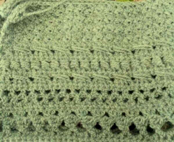Many rows of crochet, starting with tight, nubby stitches and gradually increasing to more open stitches.